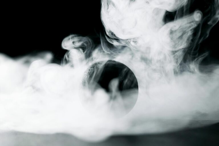 A captivating black and white image featuring a sphere obscured by swirling smoke, creating a mysterious atmosphere.